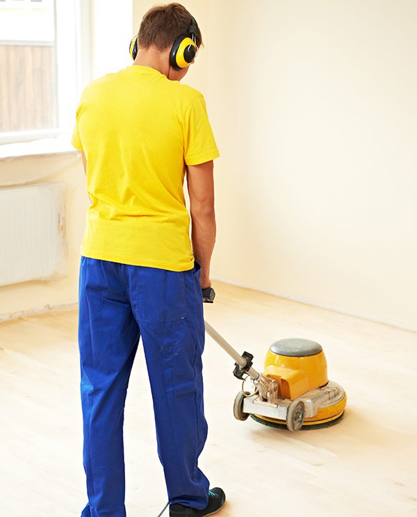 carpenter doing parquet Wood Floor polishing maintenance work by grinding machine